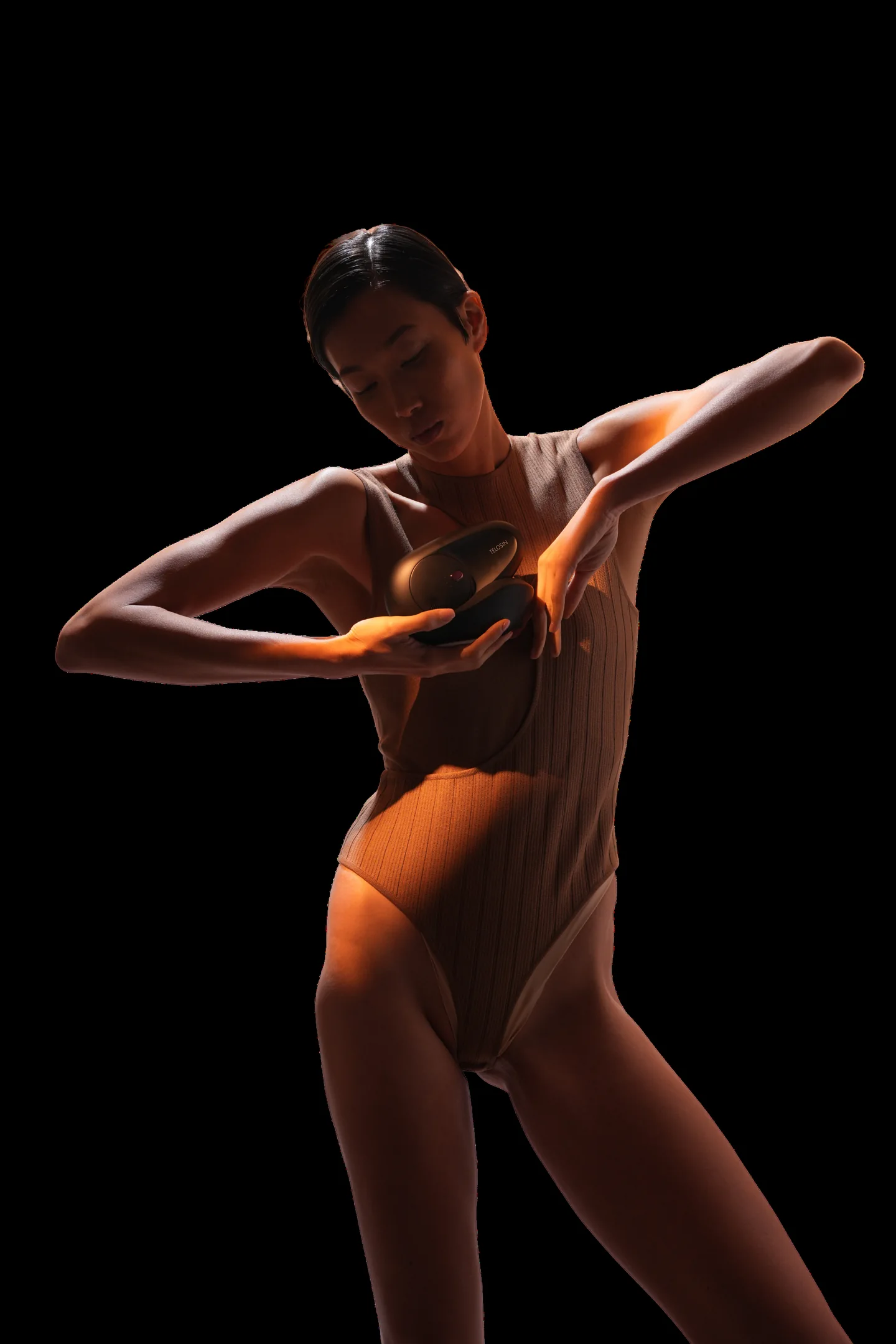 Model holding a Telosin Body Sculpt device beside her upper arm